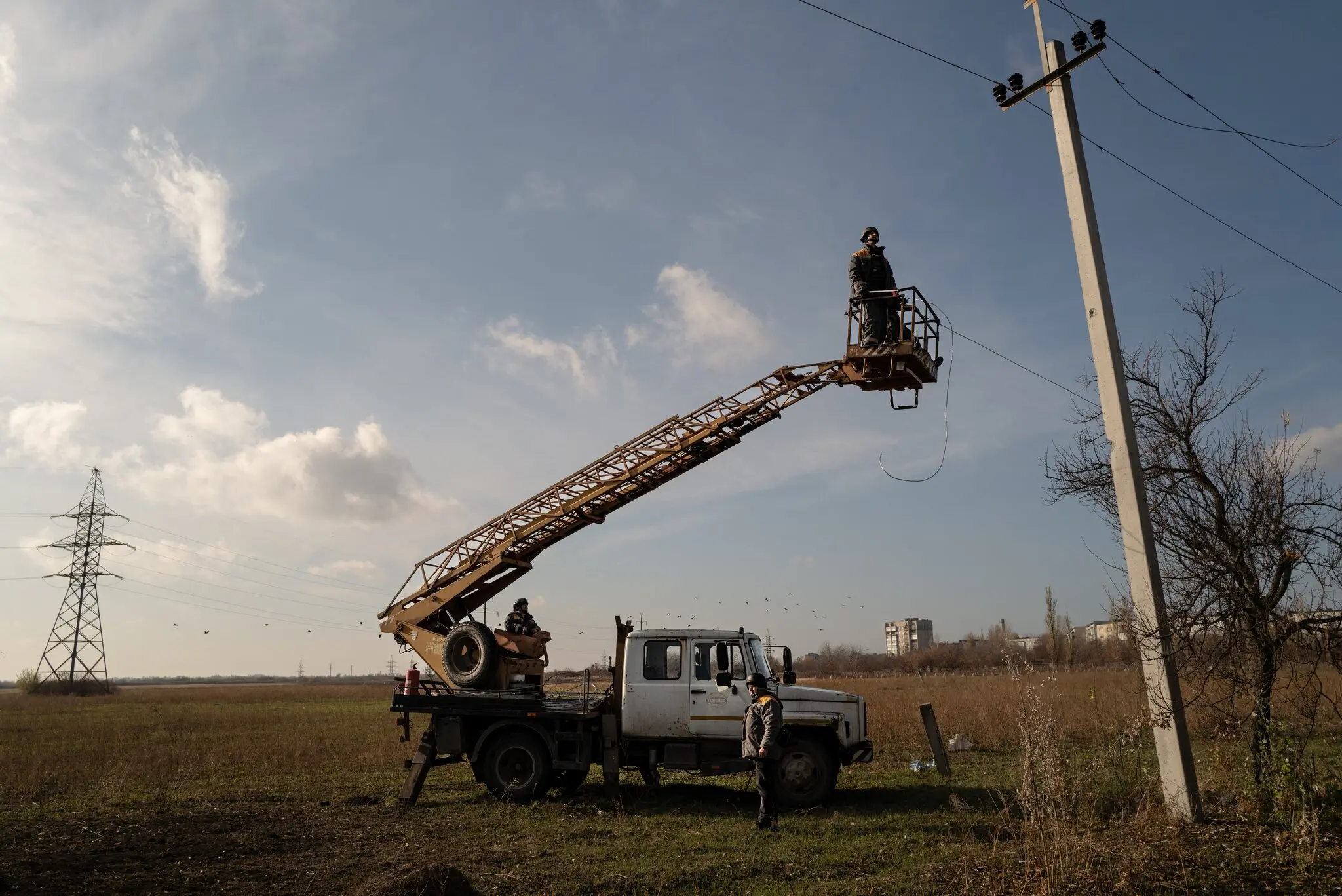Робітники ремонтують лінії електропередач, пошкоджені російськими обстрілами в листопаді на сході Донецької області України.